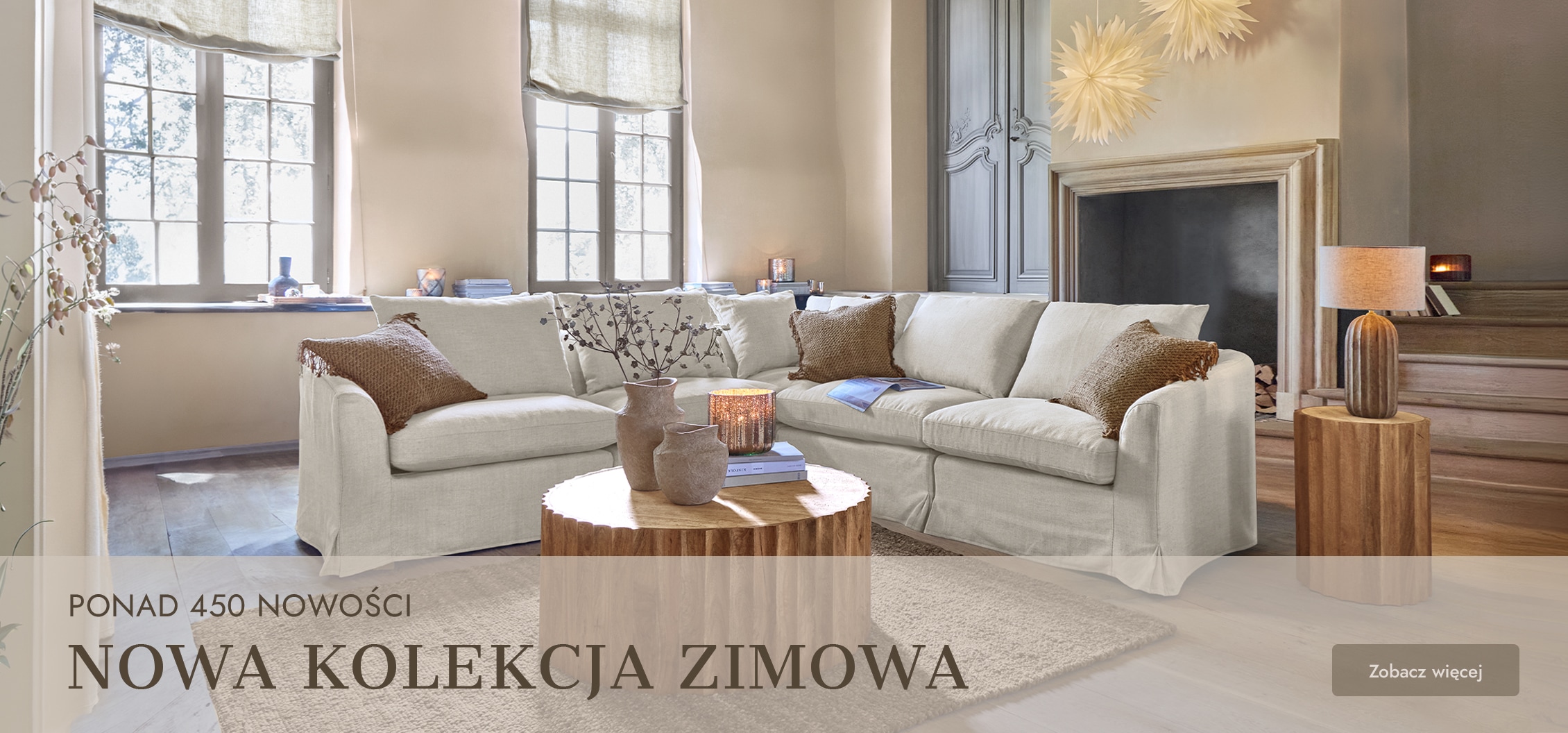 Przytulny salon z beżową narożną sofą, drewnianym stolikiem i dekoracjami w stylu zimowym