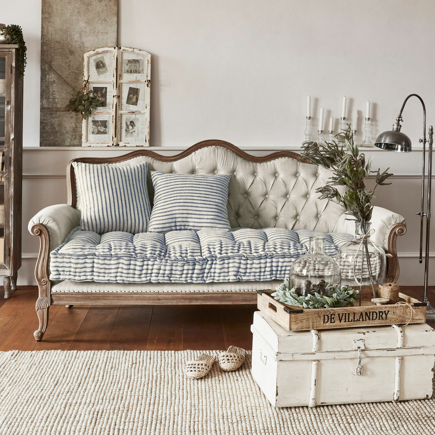 Sofa Malabon Beżowa pikowana sofa z drewnianą ramą i niebiesko-białymi poduszkami w stylu vintage