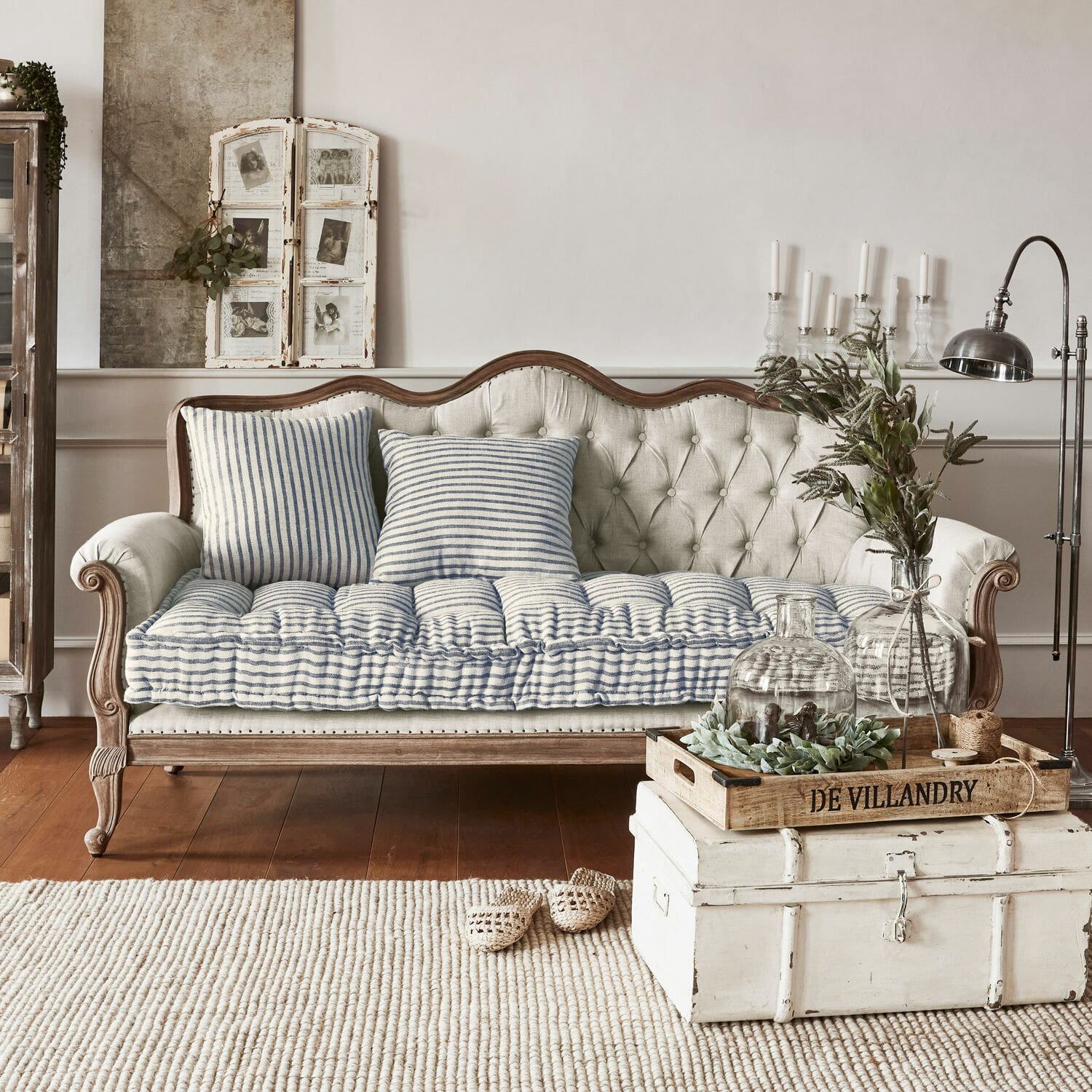 Sofa Malabon Beżowa pikowana sofa z drewnianą ramą i niebiesko-białymi poduszkami w stylu vintage