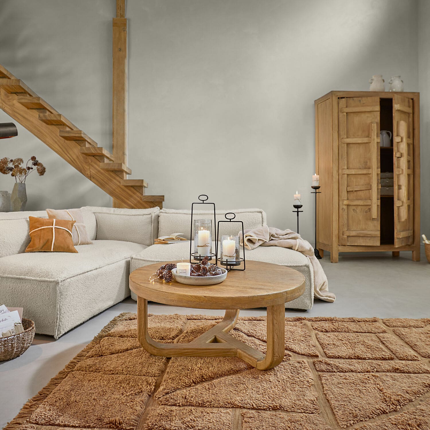 Salon z beżową sofą, drewnianą ławą i dywanem w ciepłym brązie, nowoczesne wnętrze z naturalnymi materiałami